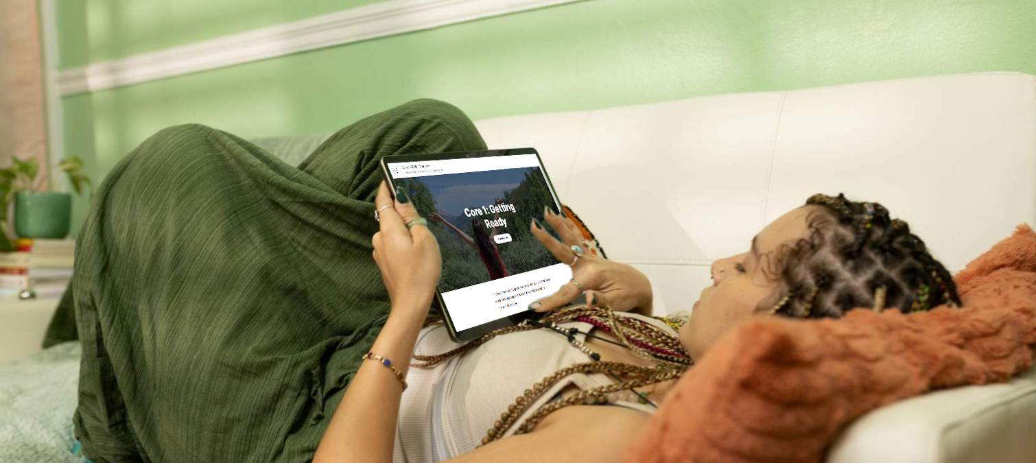Native woman laying down looking at CARRII Native on her tablet